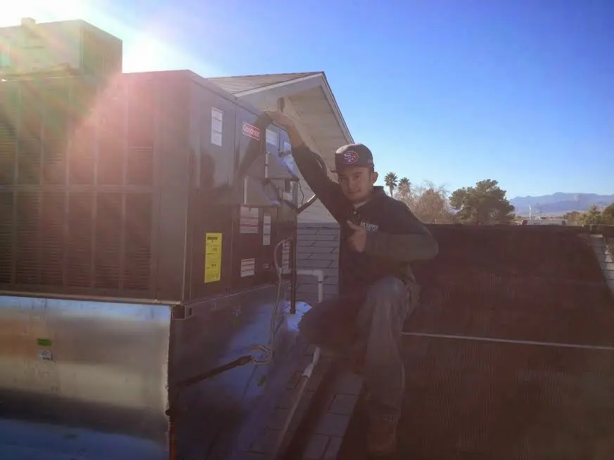 HVAC technician performing AC Tune-Up on a rooftop unit in Stillwater